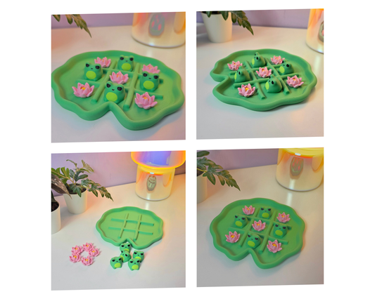 Kruisje nul spel in de vorm van een lelieblad met kikker- en bloemstukken