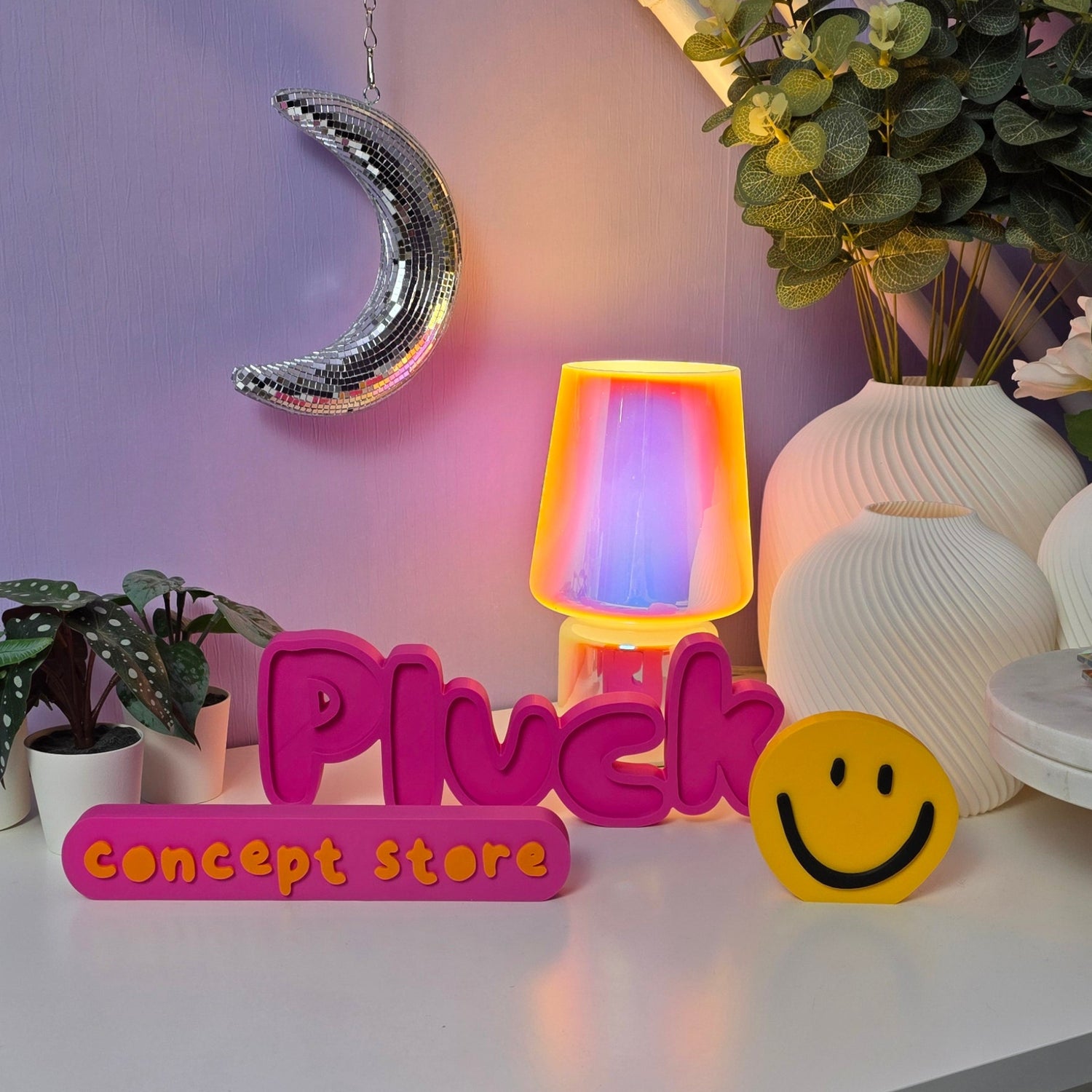 Naambeeld Pluck Concept Store in roze met smiley